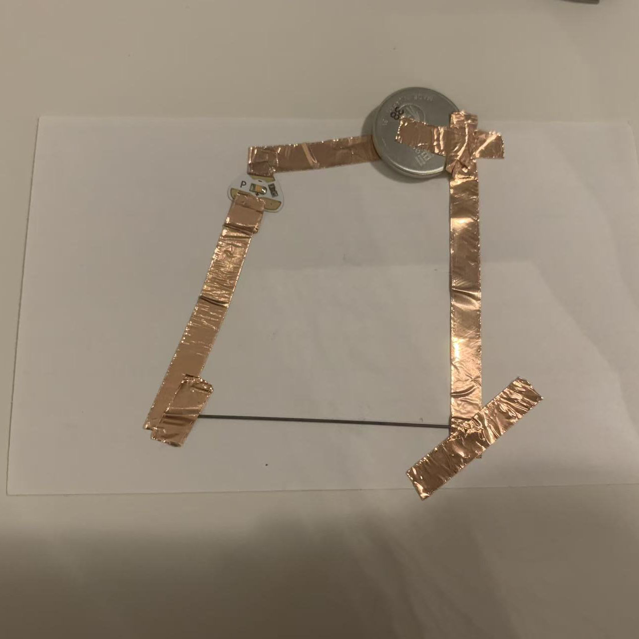 I built the circuit according to my diagram, using copper tape, a coin battery, and pencil lead to connect the components.