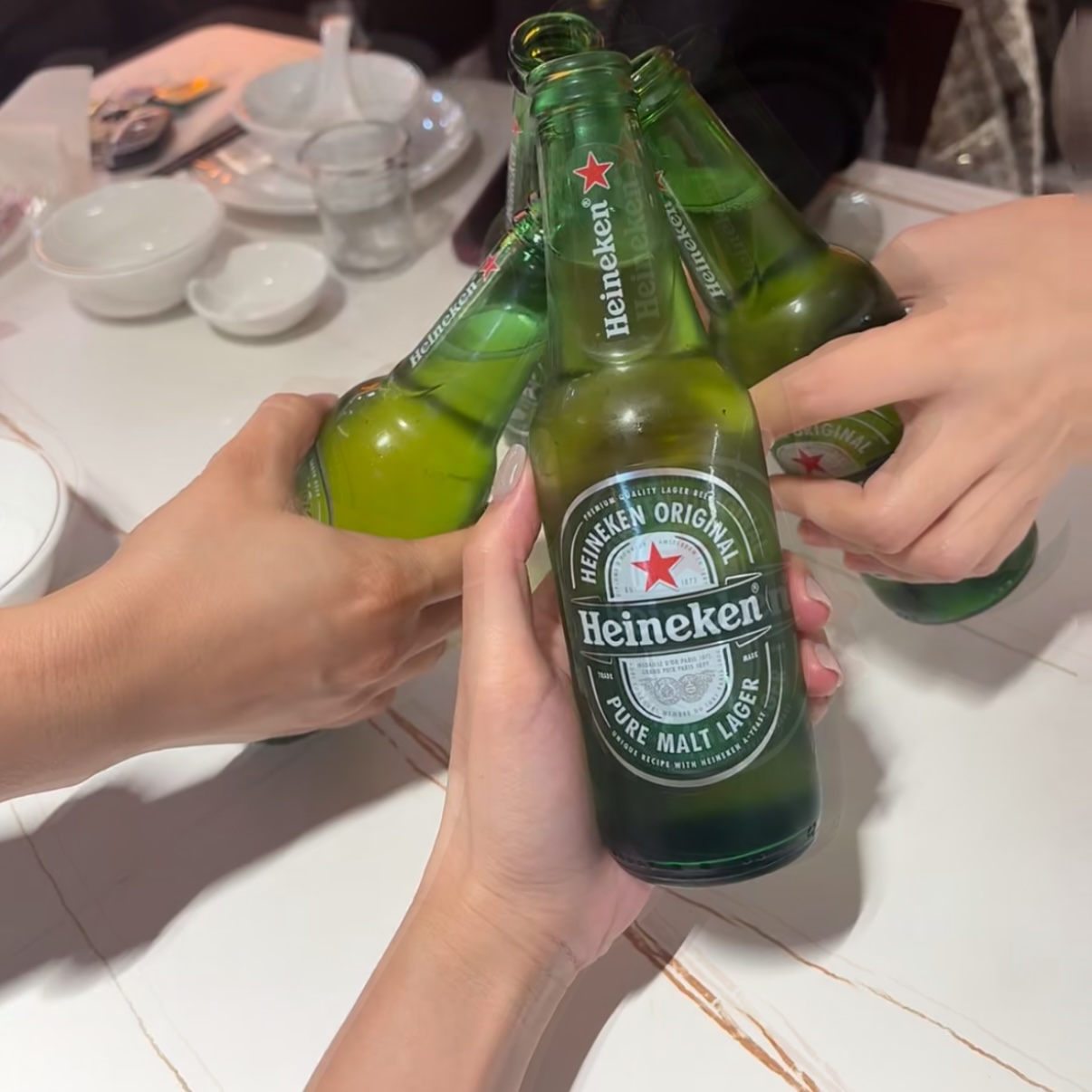 The clinking noise of glass bottles or cups touching.