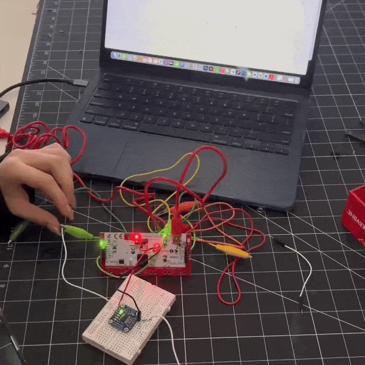 I'm connecting wires to the Makey Makey and testing them with a touchpad, activating animations on the screen.